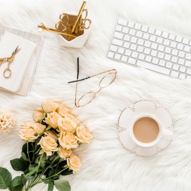 Bilgisayarlı kadın çalışma alanı, gül çiçekleri, altın aksesuarlar, günlük, dizüstü bilgisayar, beyaz arka planda gözlük. Düz uzanmış kadınların ofis masası. Üst görünüm.