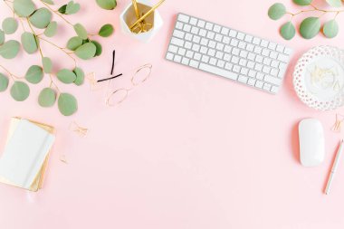 Bilgisayarlı ofis masası, yeşil yapraklı okaliptüs, dosya, altın aksesuarlar, günlük, gözlük. Dergiler, sosyal medya. Üst Manzara. Düz yatıyordu. 