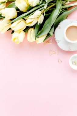Lale çiçeği buketli, altın aksesuarlı, pembe arka planlı bir kadın çalışma alanı. Düz uzanmış kadınların ofis masası. Üst görünüm kadınsı arkaplan