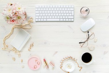 Üst kat ofis masası. Çalışma alanı, bilgisayar, kasımpatı, pano. Beyaz ahşap arka planda izole kadın aksesuarları. Düz yatıyordu