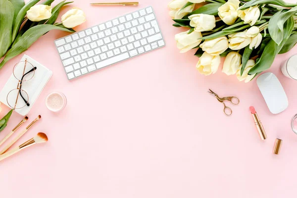 Női munkaterület számítógép, tulipán virágok csokor, arany kiegészítők, napló, rózsaszín háttér. Lapos női irodai asztal. Felülnézet — Stock Fotó