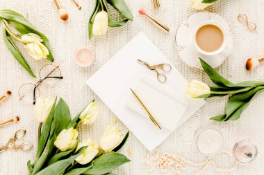 Sarı lale çiçekli kadın çalışma alanı, kadınların moda altın aksesuarları, günlük, beyaz arka planda gözlük. Düz yatıyordu. Üst görünüm kadınsı.