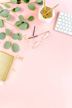 Bilgisayarlı ofis masası, yeşil yapraklı okaliptüs, dosya, altın aksesuarlar, günlük, gözlük. Dergiler, sosyal medya. Üst Manzara. Düz yatıyordu. 