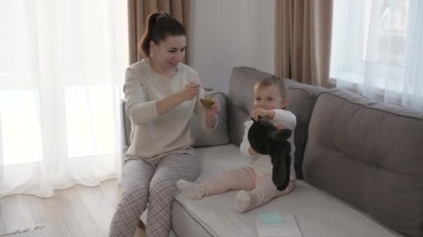 Vrouw die het kind voedt met een lepel. Moeder voeden baby met gepureerd voedsel. — Stockvideo