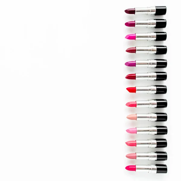 Set de lápices labiales de color sobre fondo blanco. Cosméticos decorativos profesionales, pomada de producto para publicidad. belleza, moda. plano, vista superior — Foto de Stock