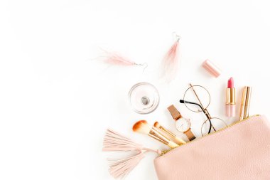 Beyaz arka planda izole edilmiş pembe kozmetik çantalı, kozmetik makyaj ürünleri içeren düz bir kompozisyon. Düz yatış, üst görünüm.