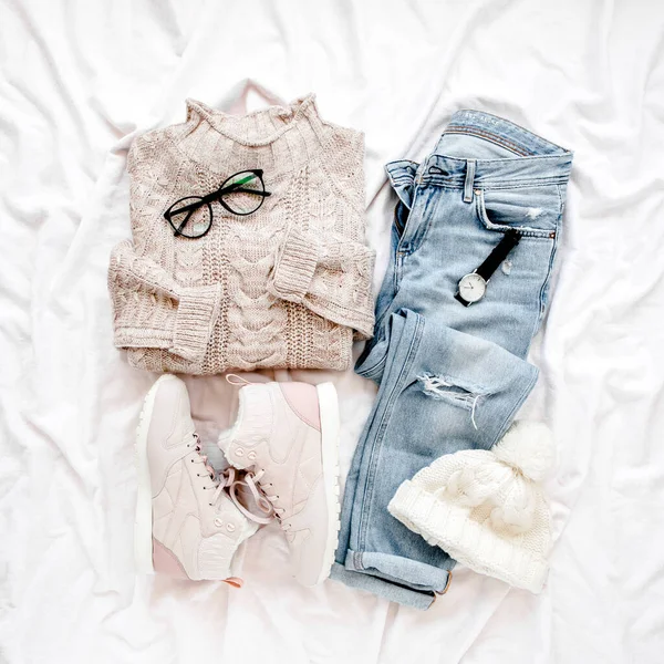 Vêtements et accessoires pour femme sur fond blanc. Pull chaud femme, jeans, baskets. Moderne et tenue. Concept de shopping. Couché plat, vue du dessus. — Photo