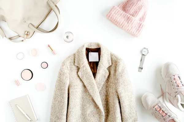 Femmes vêtements de mode et accessoires. Couché plat style automne féminin look avec manteau chaud, casquette, baskets, sur fond blanc. Vue du dessus. — Photo