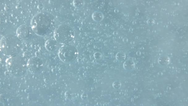 Texture de sérum bleu, fond clair de gel liquide. Mouvement de l'échantillon transparent de soins de beauté avec des bulles. Vue de dessus. Macro Shot — Video