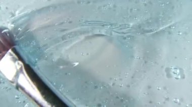 Mavi sıvı krem, kozmetik jel sıvısı, yüzeyde sürtünme hareketi. Güzellik derisi ürün örneği. Üst Manzara. Yavaş çekim