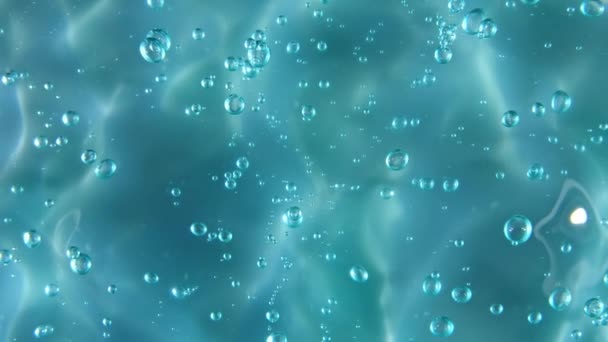 Blue serum texture, clear liquid gel background. Motion of the transparent beauty skincare product sample with bubbles. Top view. Macro Shot — Stock Video