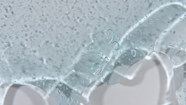 Gel cosmetico blu trasparente fluido con bolle che scorrono verso il basso su una superficie bianca. Macro Shot — Video Stock