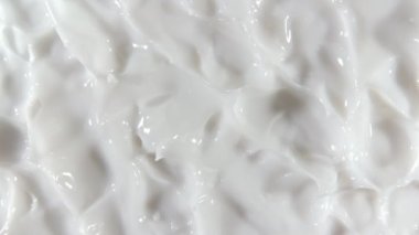 Sıvı kremin hareketi, dönüşümlü beyaz kozmetik doku. Kaplama, karalama geçmişi. Güzellik derisi ürün örneği. Ağır çekim. Üst Manzara. 4K UHD video