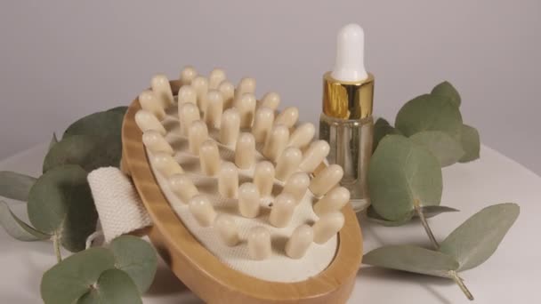Aceite de eucalipto con hojas sobre fondo blanco. Extracto de eucalipto, aceite esencial aromático. Cosméticos naturales para el cuidado del cabello y la piel. — Vídeos de Stock