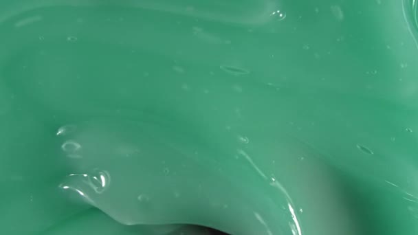 Nata líquida verde, movimento de fluido de gel cosmético, rotação em uma superfície. Amostra de produto beleza skincare. Vista superior. Movimento lento — Vídeo de Stock