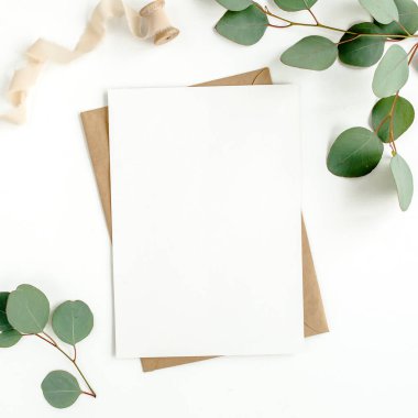 Sahte davetiye, boş tebrik kartı ve yeşil yapraklar okaliptüs. Düz yatış, üst görünüm.