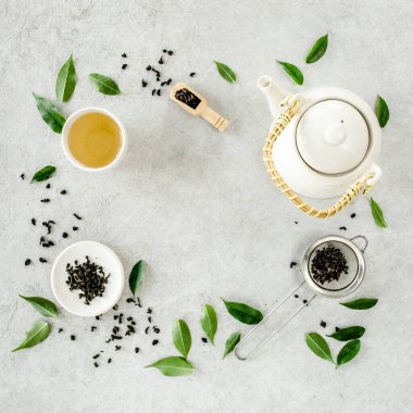 İki beyaz çay fincanı ve yeşil çay yapraklı çaydanlık ile bitki çayı. Düz yerde, üst tarafta. Çay konsepti