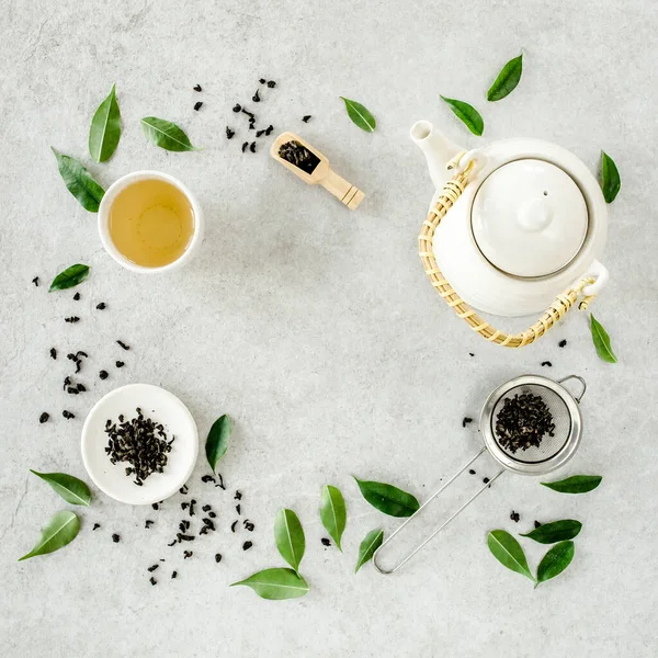 İki beyaz çay fincanı ve yeşil çay yapraklı çaydanlık ile bitki çayı. Düz yerde, üst tarafta. Çay konsepti