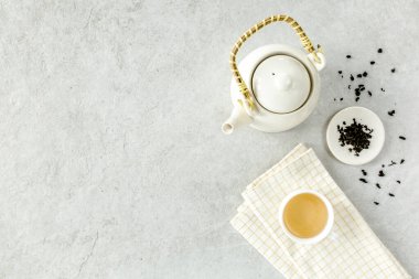 İki beyaz çay fincanı ve yeşil çay yapraklı çaydanlık ile bitki çayı. Düz yerde, üst tarafta. Çay konsepti