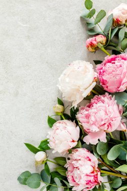 Gri taş masanın üzerinde güzel pembe şakayık çiçekleri ve metin için fotokopi alanı. Düz stil, üst görünüm