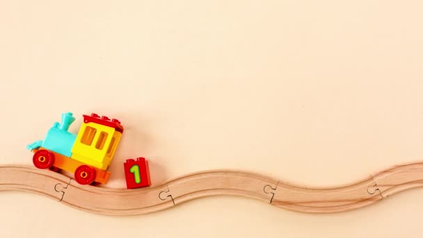 Stop animacji ruchu dzieci zabawki pociąg z liczbami na zabawki drewniane kolejki na żółtym tle. Widok z góry. — Wideo stockowe