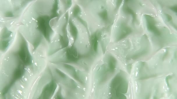 液体クリームの動き、回転と緑の化粧品の質感。接触、背景をスミアを構成します。美容スキンケア製品サンプル。スローモーション。最上階だ。4K UHDビデオ — ストック動画