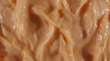 Sıvı kremin hareketi, dönüşümlü bej kozmetik doku. Kaplama, karalama geçmişi. Güzellik derisi ürün örneği. Ağır çekim. Üst Manzara. 4K UHD video