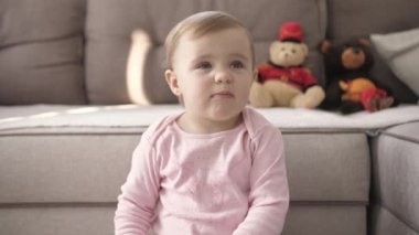 Televizyon izlerken küçük şirin bir çocuk portresi. Genç kız oturma odasında televizyon izler. Konsept video oyunu, eğlence, duygular, aile. Çocuk televizyon izliyor, küçük kızın yüzünü kapatıyor, çocuk gibi bakıyor..