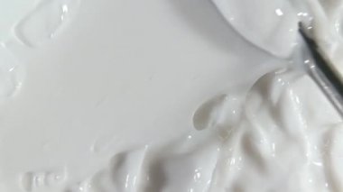 Yüz için beyaz krem, leke, kapatıcı, kozmetik sıvısı temeli, krem lekesi, makyaj fırçası. Hareket, güzellik cilt ürünü örneğinin rotasyonu. Yavaş çekim