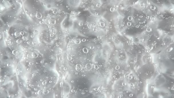 Transparent liquid gel background, clear serum texture. Motion, rotation of the beauty skincare product sample with bubbles. Top view. Macro Shot — Stock Video