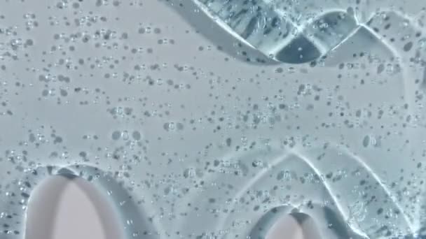 白い表面に泡が流れる透明ブルー化粧品ジェル液。マクロショット — ストック動画