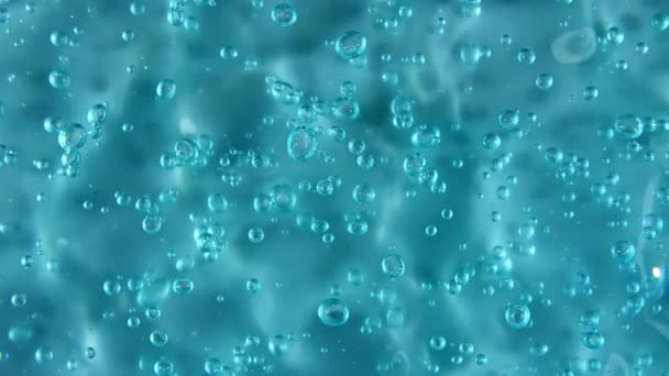 Mouvement, rotation du liquide gel liquide, texture crème cosmétique bleue avec bulles. Cosmétiques biologiques, médicaments. Vue de dessus. Macro Shot — Video