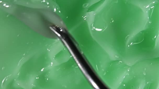 Grüne flüssige Creme, kosmetische Gelflüssigkeit Bewegung, Rotation auf einer Oberfläche. Schönheitspflegeprodukt Probe. Ansicht von oben. Zeitlupe — Stockvideo