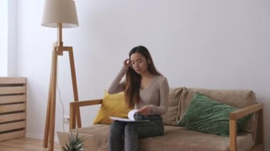 Orta Doğulu uzaktan kumandalı bir kadın. Evrakları kontrol ediyor. Evde kal, uzaktan kumandayı karantinaya al. Yavaş çekim.