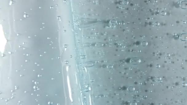 Blue serum texture, clear liquid gel background. Motion of the transparent beauty skincare product sample with bubbles. Top view. Macro Shot — Stock Video