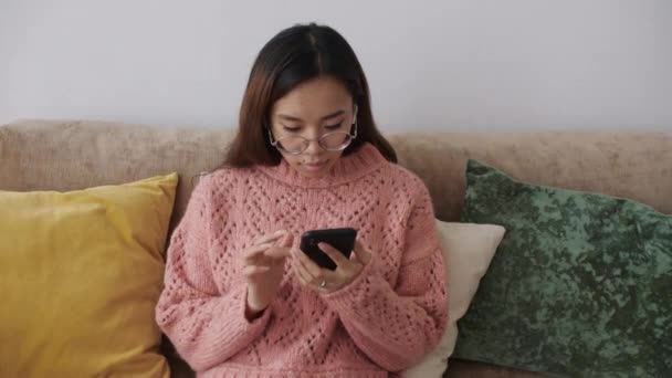 Středovýchodní mladá žena sedí na pohovce v obývacím pokoji s chytrým telefonem a nakupuje on-line na internetu Supermarket, on-line, doručování, jídlo, objednávky. Technologie buněčných zařízení. — Stock video