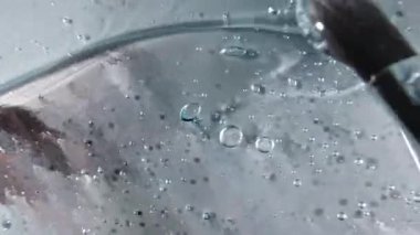 Mavi sıvı krem, kozmetik jel sıvısı, yüzeyde sürtünme hareketi. Güzellik derisi ürün örneği. Üst Manzara. Yavaş çekim