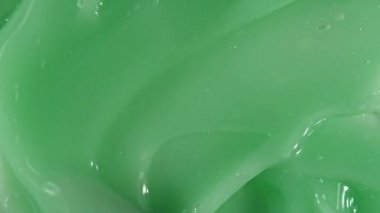 Yeşil sıvı krem, kozmetik jel sıvı hareketi, yüzeyde dönüş. Güzellik derisi ürün örneği. Üst Manzara. Yavaş çekim