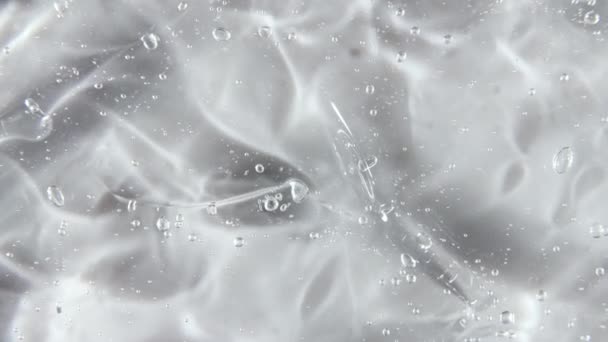 Transparent liquid gel background, clear serum texture. Motion, rotation of the beauty skincare product sample with bubbles. Top view. Macro Shot — Stock Video