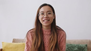 Orta Doğulu genç bir kadın web kamerasına kulaklık takıyor ve bilgisayarla uzaktan video konferans görüşmesi yapıyor. Hücre aletleri teknolojisiyle evde zaman geçiren bir kadın.