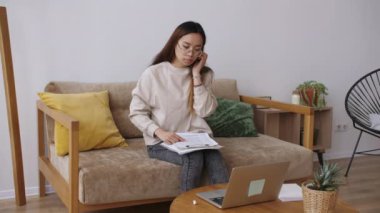 Orta Doğulu kadın uzaktan kumanda, iş arkadaşlarıyla görüntülü görüşme, belgeleri kontrol. Evde kal, uzaktan kumandayı karantinaya al. Yavaş çekim.