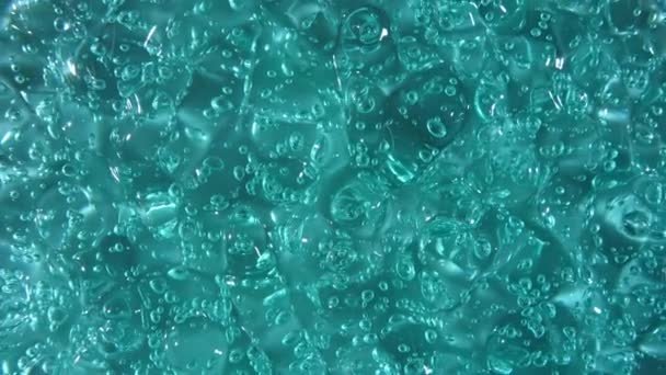 Rörelse, rotation av flytande gel vätska, turkos kosmetisk kräm konsistens med bubblor. Ekologisk kosmetika, medicin. Högst upp. Makroskott — Stockvideo