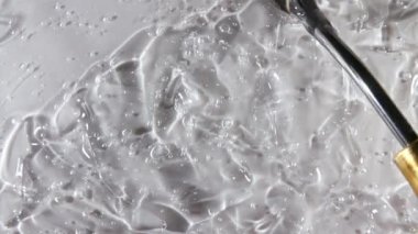 Şeffaf sıvı jel arka plan, açık serum dokusu. Hareket, cilt bakımı, baloncuklu ürün örneği. Üst Manzara. Makro Vuruş