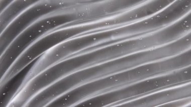 Şeffaf sıvı jel arka plan, açık serum dokusu. Hareket, cilt bakımı, baloncuklu ürün örneği. Üst Manzara. Makro Vuruş