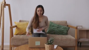 Orta Doğulu kadın uzaktan kumanda, iş arkadaşlarıyla görüntülü görüşme, belgeleri kontrol. Evde kal, uzaktan kumandayı karantinaya al. Yavaş çekim.