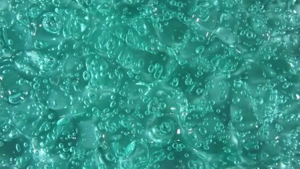 Movimiento, rotación del líquido gel fluido, textura crema cosmética turquesa con burbujas. Cosmética ecológica, medicina. Vista superior. Macro Shot — Vídeo de stock