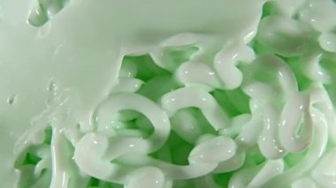 Sıvı kremin hareketi, dönüşümlü yeşil kozmetik doku. Kaplama, karalama geçmişi. Güzellik derisi ürün örneği. Ağır çekim. Üst Manzara. 4K UHD video