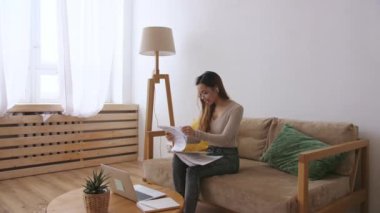 Orta Doğulu uzaktan kumandalı bir kadın. Evrakları kontrol ediyor. Evde kal, uzaktan kumandayı karantinaya al. Yavaş çekim.