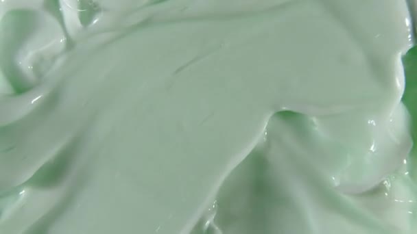 Motion of the Liquid cream, green cosmetic texture with rotation. Contouring, Make up smears background. Beauty skincare product sample. Slow motion. Top view. 4K UHD video — Stock Video