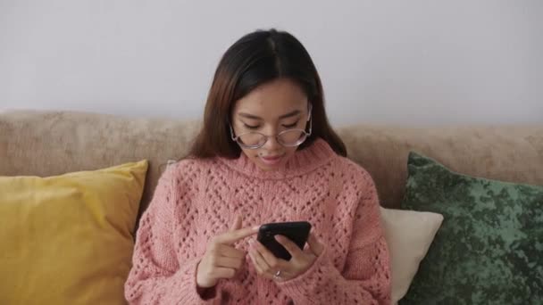 Středovýchodní mladá žena sedí na pohovce v obývacím pokoji s chytrým telefonem a nakupuje on-line na internetu Supermarket, on-line, doručování, jídlo, objednávky. Technologie buněčných zařízení. — Stock video